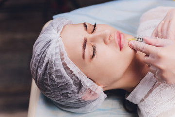 woman receiving a injection in her lips, close up.