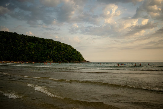 Enseada com banhistas e turistas na praia em lindo dia pitoresco com montanhas
