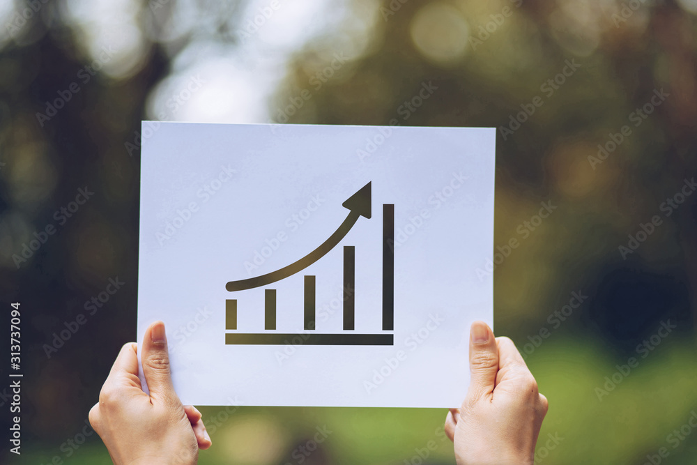 Poster show business paper graph statistics,arrow showing the chart in hand on nature background
