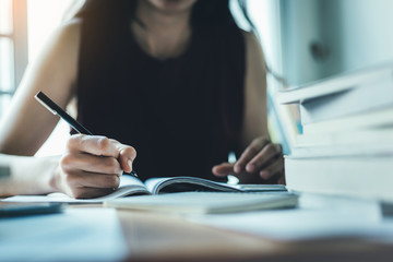 high school,college,university student writing in classroom or library at work space with book...