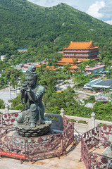 Fototapeta na wymiar Buddhist statue praising and making offerings to the Tian Tan Buddha with Po Lin Monastery at background in Lantau island, Hong Kong
