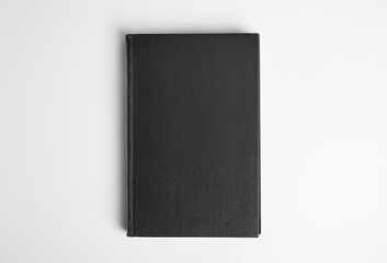 Hardcover book on white background, top view. Space for design