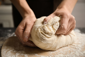 Woman beating dough at table, closeup. Making pasta