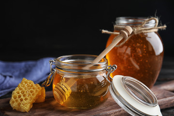 Jar of sweet honey on wooden board