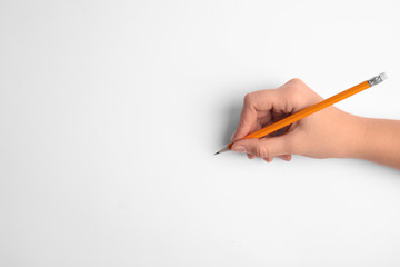 Woman holding pencil on white background, top view