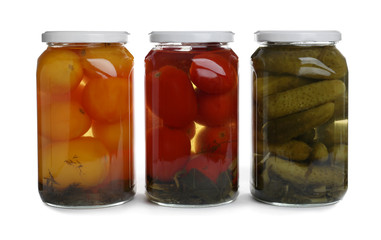 Glass jars of different pickled vegetables isolated on white