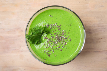 Tasty kale smoothie with chia seeds on wooden table, top view