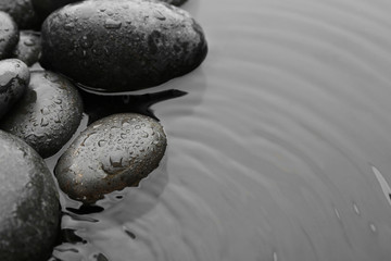 Beautiful spa stones in water, space for text. Zen lifestyle