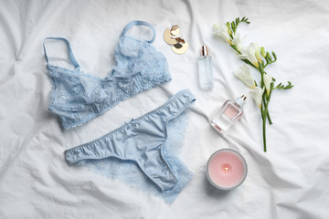 Flat lay composition with sexy women's underwear on white fabric