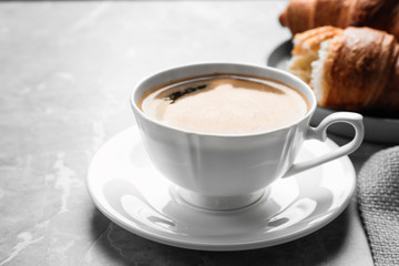 Coffee and tasty croissants on light grey marble table, closeup