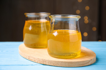 Tasty aromatic honey on light blue wooden table