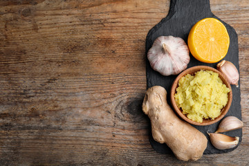 Fresh garlic and other natural cold remedies on wooden table, top view. Space for text