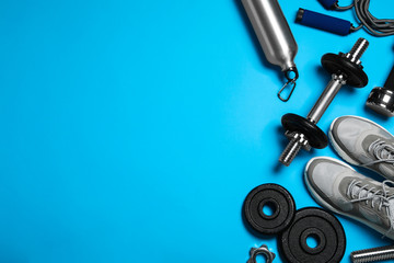 Gym equipment on light blue background, flat lay. Space for text