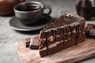 Piece of delicious chocolate cake on grey table
