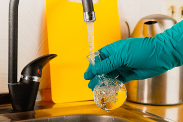 water purification specialist tap water pours into a glass flask.