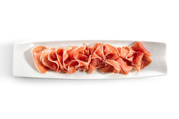 Sliced Jamon Iberico, Prosciutto or Speck on Restaurant Plate Isolated