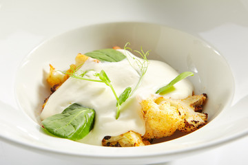Baked Cauliflower with Cream Sauce and Fresh Greens Isolated