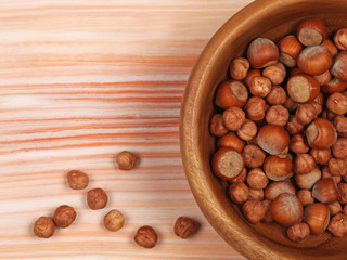 Raw hazelnuts on light wooden background