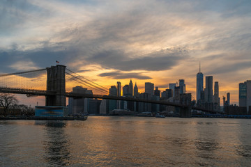 Naklejka na ściany i meble scene of New york Cityscape with Brooklyn Bridge over the east river at the sunset time, USA downtown skyline, Architecture and transportation concept