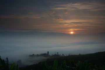 Sea of fog overwhelming a village with sunrise sky in background