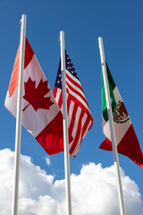 Flags of United States, Mexico, Canada fluttering in the sky
