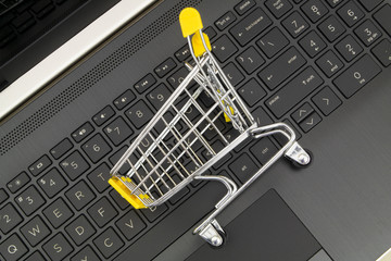 Shopping cart on laptop computer keyboard. Online shopping concept.