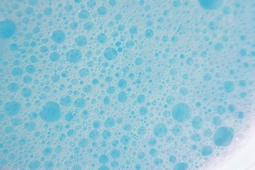 blue soap foam macro background.soap bubbles blue pastel color with a white gradient. Detergent texture. Shower gel. Purity and freshness. Bath foam. 
