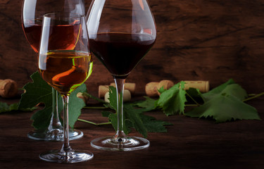 Wine set. Red, white and rose wine in assortment in wineglasses. Wine tasting, vintage wooden background, selective focus, copy space