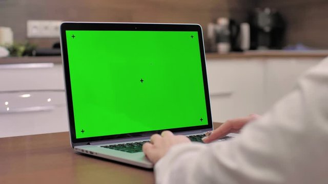 Woman using laptop computer with laptop green screen, 4K shot. Technology, chroma key, template, mockup and entertainment concept.