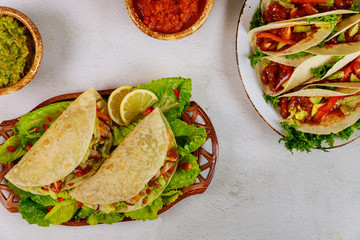 Mexican tasty food soft tortilla stuffed with green salad and meat.