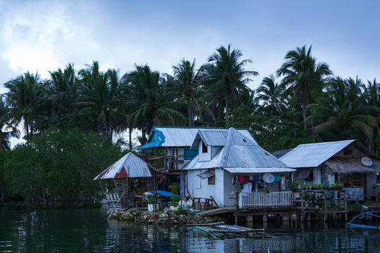 Basic Homes On Stilts Above Water In Local Village