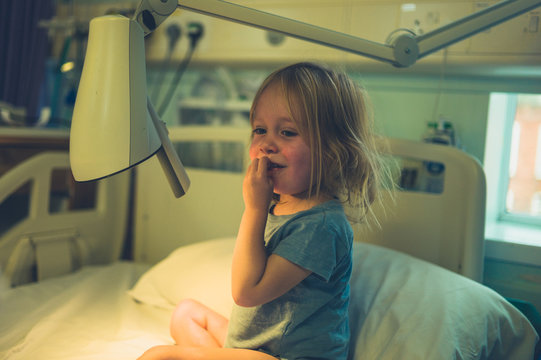 Little toddler in hospital bed with a lamp
