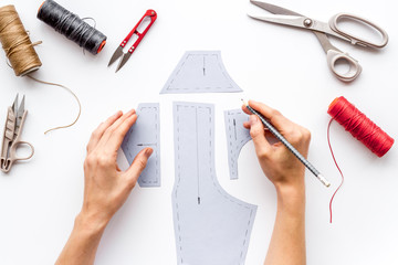 Tailor working. Women hands drawing patterns for clothes on white background top-down