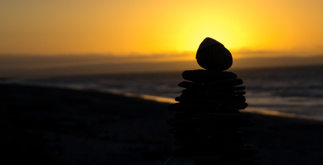 silhouette of rocks on the beach at sunset