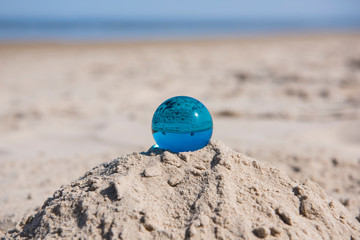 Glass sphere at the beach. Sunny Spring day.