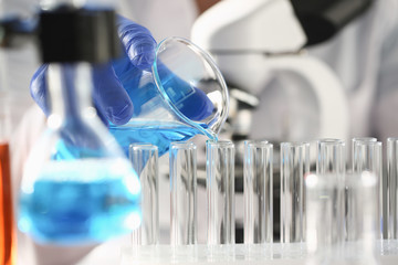 A male chemist holds test tube of glass in his hand