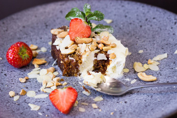 Carrot biscuit pie with cream. Cake with strawberries and lime on a beautiful plate. Photo close up. Dessert in a restaurant with fruit and nuts. Beautiful laying of food.