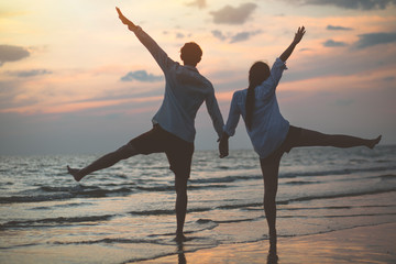 Obraz premium Romantic couple enjoying a beach walk at sunset