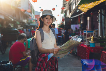 Outdoors lifestyle of beautiful young woman. traveler young woman standing looking map smiling on holiday festival outdoor market famous with backpack , tourism shopping Festive mood, Traveler