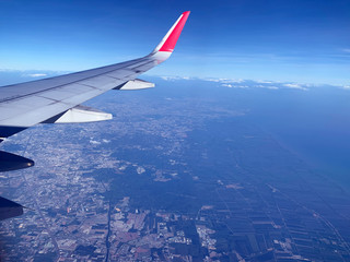 Obraz premium wing of an airplane flying above the clouds