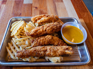 Close up shot of a plate of deep fried chicken breast and potato slice