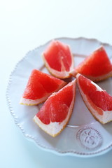 Cut fruit, red ruby grapefruit on dish for healthy dessert