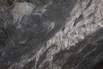 Gray karst cave. Rock formations in the cave, stalactites and stalagmites. Abstract gray grunge background. Stone texture background. Spotted abstract stone. Russia, Bashkortostan, a fairy cave