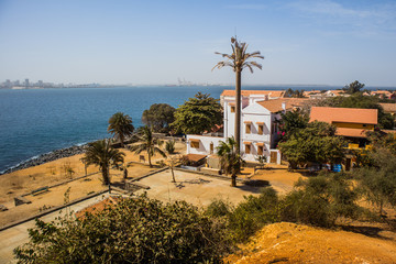 Sunlit houses on the famous slave trade island of Goree in the atlantic ocean just outside of Dakar city. Dakar skyline is seen in the background.