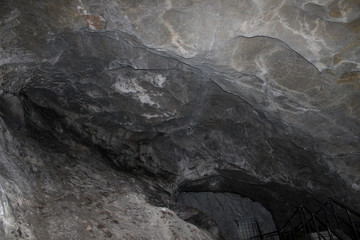 Gray karst cave. Rock formations in the cave, stalactites and stalagmites. Abstract gray grunge background. Stone texture background. Spotted abstract stone. Russia, Bashkortostan, a fairy cave.