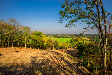 The blurry nature background of the Wat Saphan Hin walkway has long, stone bridges on a hill, with tourists coming to see the beauty in Sukhothai, Thailand.