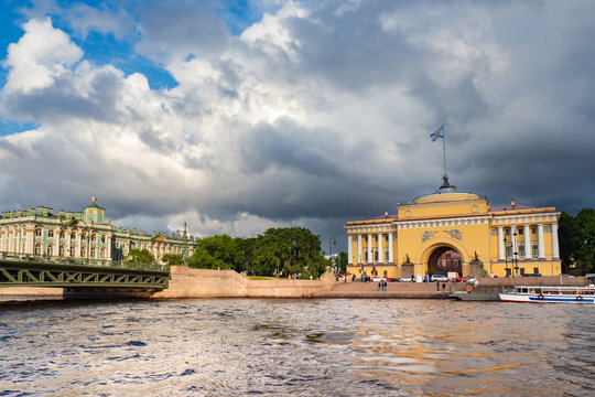 Saint Petersburg. Russia. Admiralty on a cloudy summer day. Gray clouds over the Neva. Rivers Of St. Petersburg. Bridges Of St. Petersburg. View of the Hermitage from Vasilievsky island.