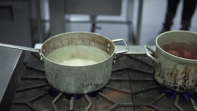 Array of pots that has different soups in them. This was taken at a higher frame rate and has been converted to a slow motion video clip.