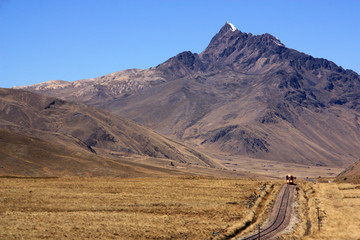 A Train making it's Way through a wide Valley within the Andes Mountain Range in Peru