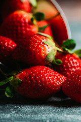 Ripe and juicy strawberries on the dark rustic background. Selective focus. Shallow depth of field.